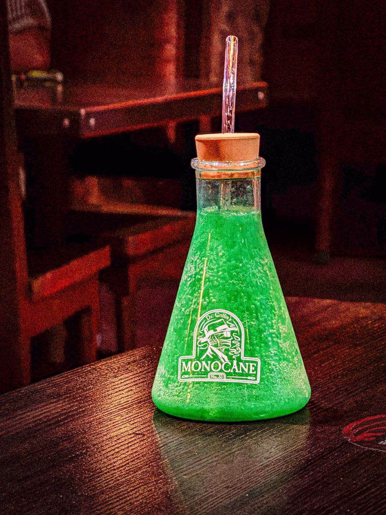 MONOCANE green liqueur bottle on dark wooden bar, commercial product photography