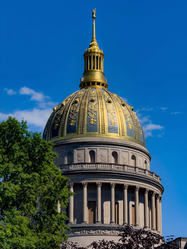West Virginia State Capitol building golden dome against bright blue sky, architectural photography