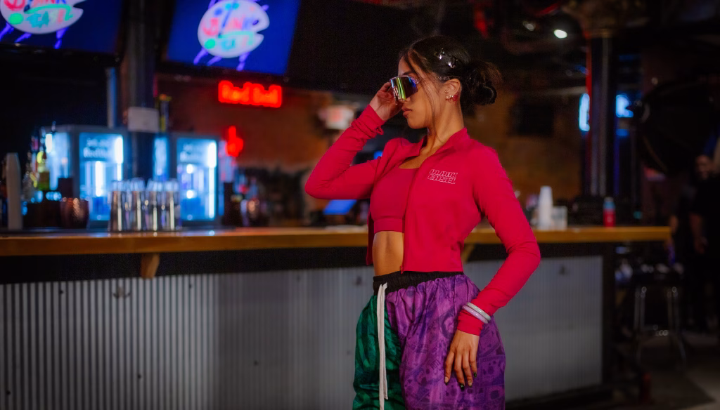 Editorial portrait of model in red track jacket at bar venue, Streetwear event, Spring 2026